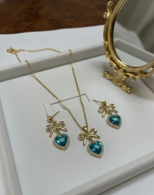 Dainty Gold Ribbon Stud Earrings with Aquamarine Heart Detail