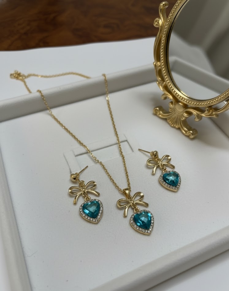 Dainty Gold Ribbon Stud Earrings with Aquamarine Heart Detail